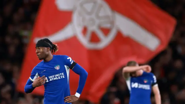 Noni Madueke and Alfie Gilchrist of Chelsea look dejected in front of an Arsenal flag at Emirates Stadium