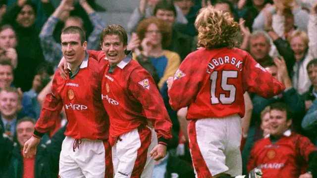 Eric Cantona celebrates a goal with David Beckham for Manchester United