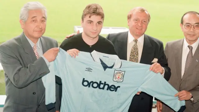 Georgi Kinkladze poses with a Manchester City shirt