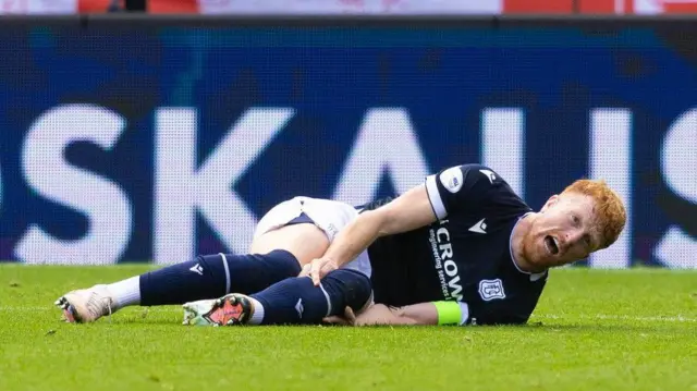 Simon Murray clutches his knee after picking up an injury against Aberdeen