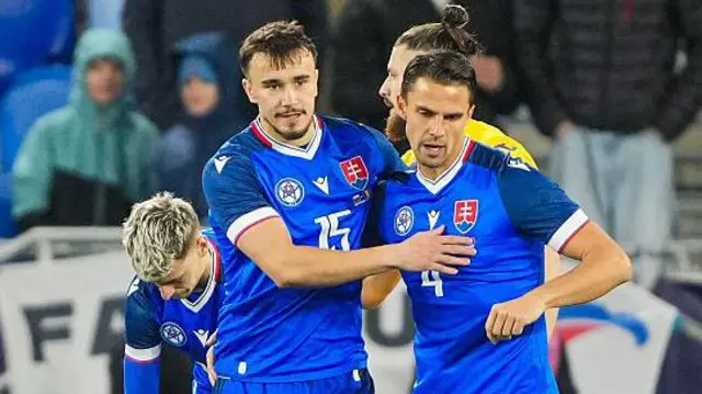 David Strelec in an all-blue Slovakia kit celebrates with a team-mate after scoring a goal against Romania