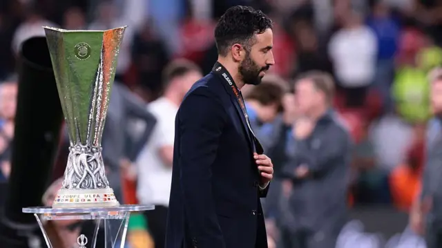 Ruben Amorim walks past Europa League trophy