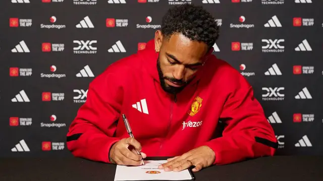 Matheus Cunha signing his Manchester United contract