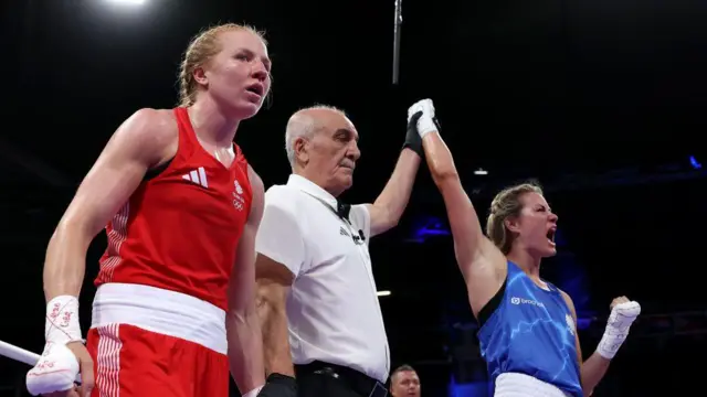  Rosie Eccles of Team Great Britain looks on as Referee Farzad Sadegh Poor raises the hand of Aneta Rygielska of Team Poland 