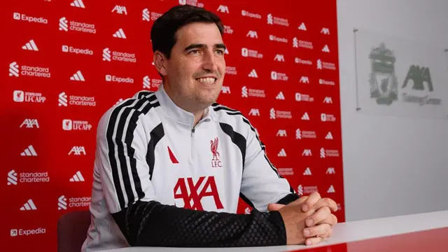 Andoni Iraola sits and smiles Liverpool's AXA training centre media room