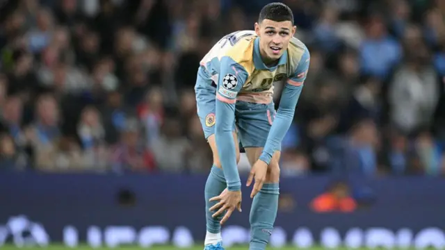 Phil Foden reaches down and looks on during match for Manchester City