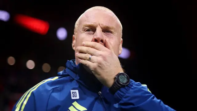 Sean Dyche stands on the touchline in a tracksuit