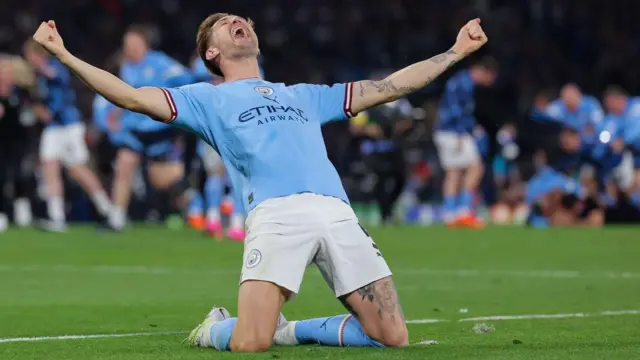 John Stones celebrates on his knees at full-time of the 2023 Champions League final