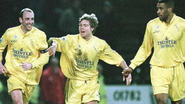 Gary McAllister of Leeds (left) celebrates with teammate Thomas Brolin (middle) after scoring the match-winning goal against Port Vale in the last minute of the FA Cup fifth round replay match at Vale Park
