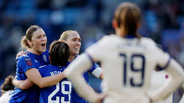 Leicester City players celebrate at full time as Chelsea players stand deflated