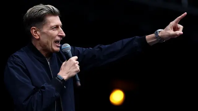 Steve Parish speaks into a microphone to address supporters
