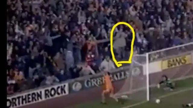 Image of an old Wolves game with Steve Bull scoring and a fan circled behind the goal