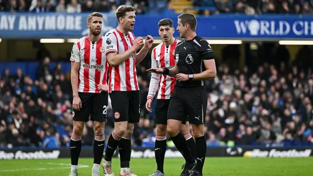 Brentford players arguing with the referee