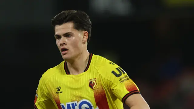 A close-up of forward Luca Kjerrumgaard playing for Watford in their yellow and red home kit