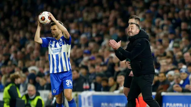 Joel Veltman looks on as Roberto de Zerbi, manager of Brighton & Hove Albion, gives the team instructions