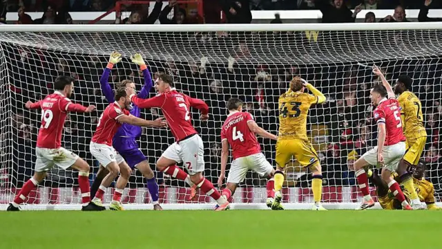 Wrexham players celebrate defender Max Cleworth's goal