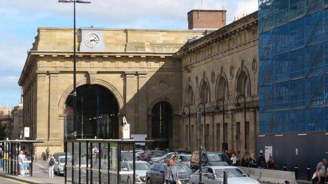 The portico outside Newcastle Central Station. One of the three Victorian clocks stands at the top of the building. It is showing the wrong time.