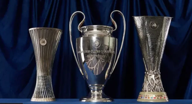 Europa Conference League trophy, Champions League trophy and Europa League trophy stand next to one another