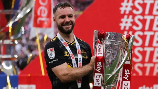 Adam Armstrong poses for a photo while holding the Championship play-off trophy