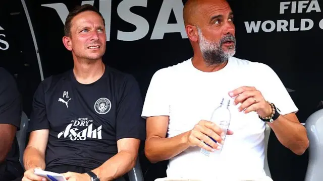 Pep Lijnders and Pep Guardiola sit next to each in a dugout at the Club World Cup