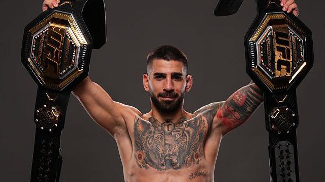 Ilia Topuria poses with his UFC title belts