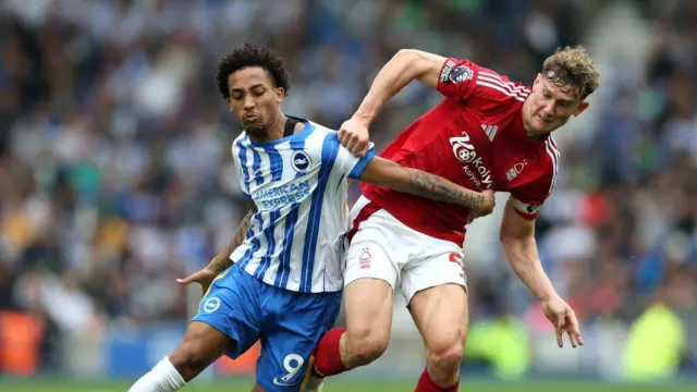 Joao Pedro of Brighton & Hove Albion is challenged by Ryan Yates of Nottingham Forest during the Premier League match between Brighton & Hove Albion FC and Nottingham Forest FC at Amex Stadium