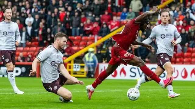 Hearts' Stuart Findlay fouls Aberdeen's Toyosi Olusanya