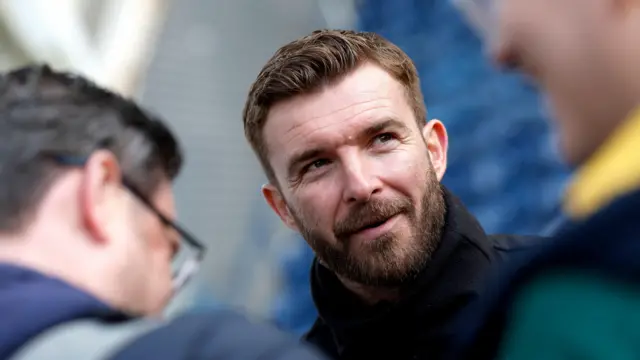A close up of James Morrison wearing a high neck black jacket