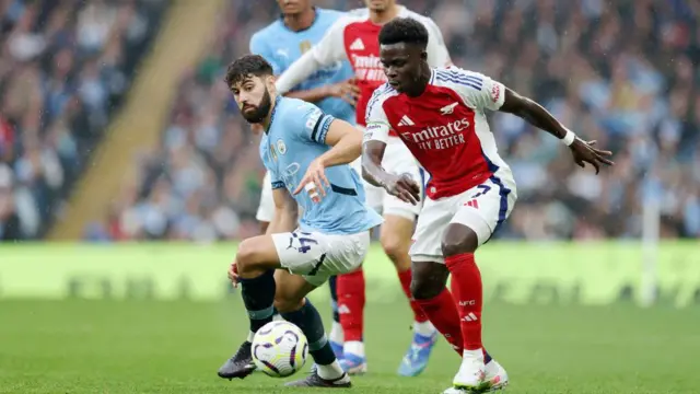 Josko Gvardiol of Manchester City battles for possession with Bukayo Saka of Arsenal during the Premier League match between Manchester City FC and Arsenal FC at Etihad Stadium