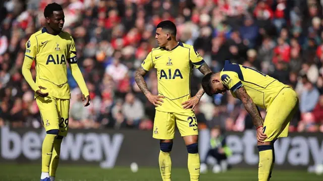 Pape Matar Sarr, Pedro Porro, and Cristian Romero of Tottenham Hotspur show dejection
