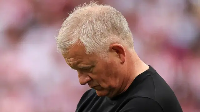A photo of Chris Wilder looking down
