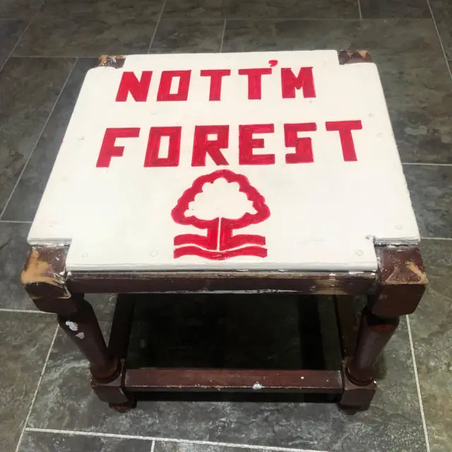 A picture of a stool with a white seat and the words Nott'm Forest and the club crest on