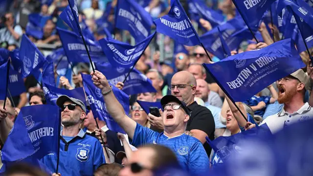 Everton fans waving Everton flags.