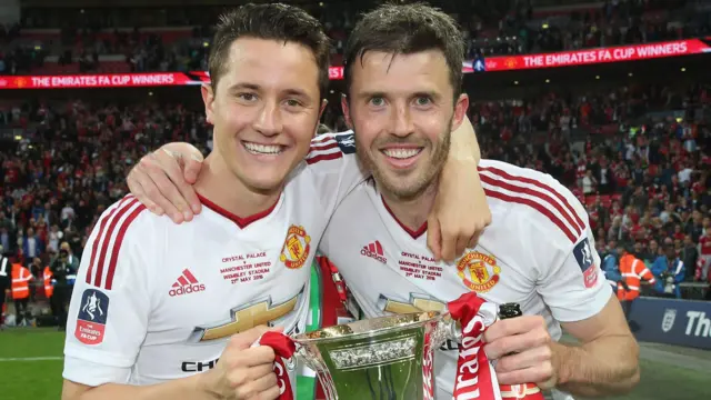 Ander Herrera and Michael Carrick holding the FA Cup together after Manchester United beat Crystal Palace in 2016