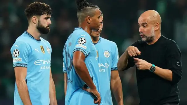 Pep Guardiola speaks to his players near the touchline