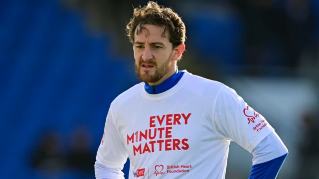 Bristol Rovers defender Tom Lockyer wearing an Every Minute Matters t-shirt in the warm-up before a game