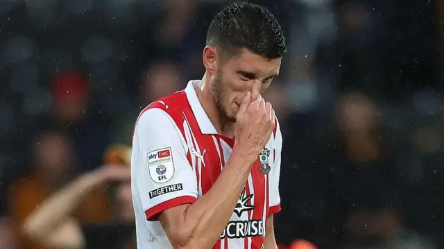 Southampton striker Ross Stewart clasps his nose in frustration