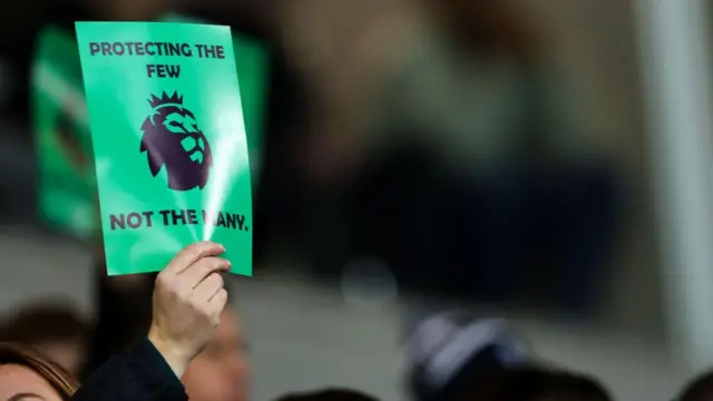 A fan of Everton holds a piece of paper in protest against the Premier League