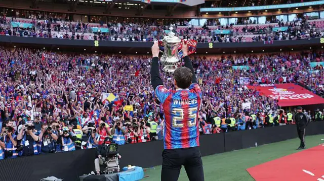 Oliver Glasner holds up the FA Cup in front of the crowd at Wembley