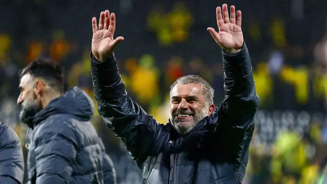 Ange Postecoglou smiling and holding his arms in the air