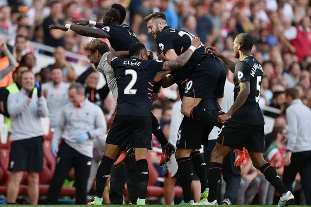 Sadio Mane on Jurgen Klopp's back with other Liverpool players celebrating after the forward had scored the fourth goal against Arsenal in August 2016