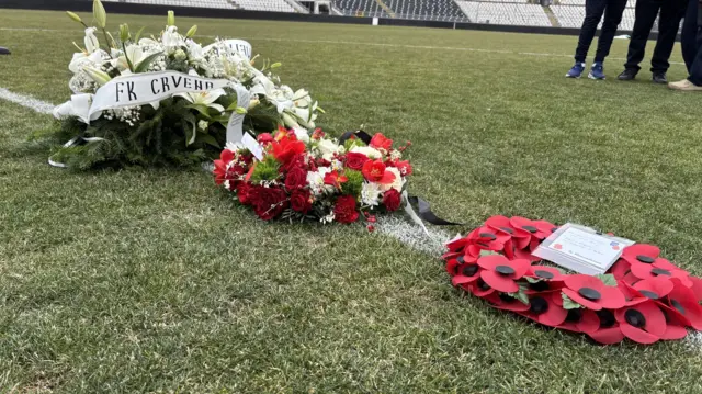 Three wreaths laid on a football field