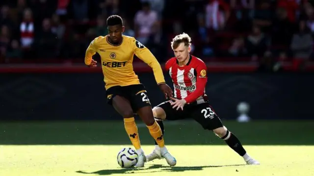 Nelson Semedo of Wolverhampton Wanderers is challenged by Keane Lewis-Potter of Brentford