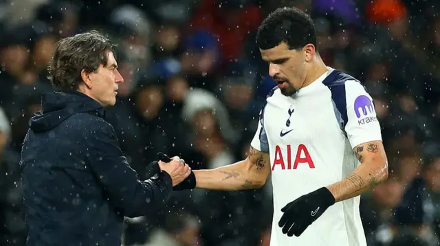 Dominic Solanke and Thomas Frank shake hands. Solanke is in Tottenham's home kit