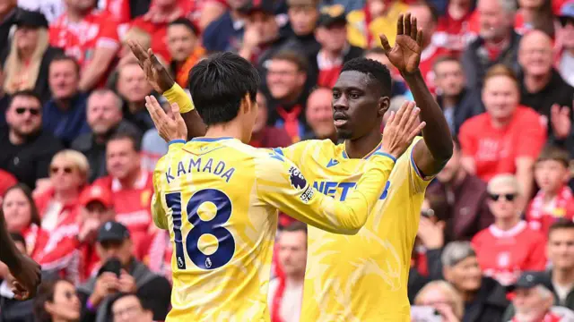 Ismaila Sarr celebrates with team-mate Daichi Kamada after scoring the opening goal against Liverpool at Anfield