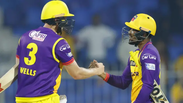 Luke Wells congratulates Avisha Fernando on his half-century