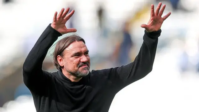Daniel Farke with his arms in the air acknowledging the fans