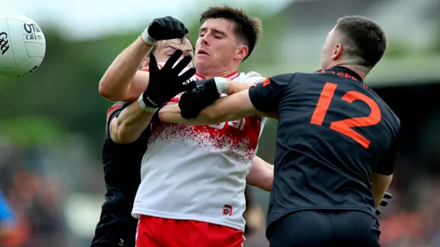 Oisin Conaty and Barry McCambridge battle for possession with Conor Doherty