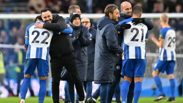 De Zerbi embraces Karou Mitoma as his Brighton side celebrate beating Liverpool on the pitch after full-time