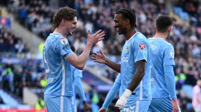 Jack Rudoni engaging in a celebratory handshake with Coventry City team-mate Haji Wright